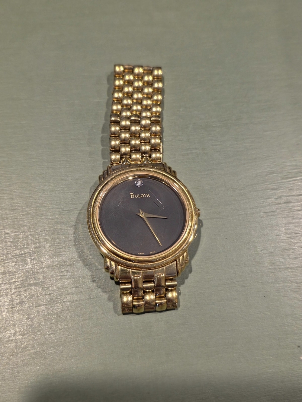 Bulova Gold Tone Watch with Black Dial and Single Crystal Accent
